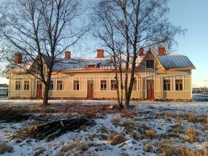 a large yellow house with trees in the snow at Willa Viktor in Kristinestad