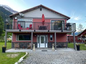 a red house with a balcony with chairs on it at Guesthouse Austria in Stewart +35 photos