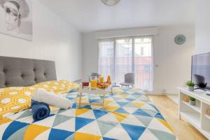1 dormitorio con 1 cama grande con una manta colorida en DÉPLACEMENT PRO & TOURISME - NETFLIX - WIFI - Easy CHECK-IN, en Bourg-la-Reine