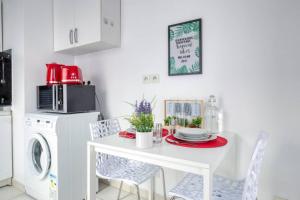 cocina blanca con mesa y lavadora en DÉPLACEMENT PRO & TOURISME - NETFLIX - WIFI - Easy CHECK-IN, en Bourg-la-Reine