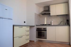 uma cozinha com armários brancos e um fogão em Casa Ligure Ristrutturata 80m2 em Diano Marina