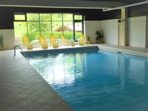 a large swimming pool with yellow chairs at Apartment Almrock in Maria Alm am Steinernen Meer