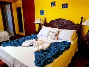um quarto com uma cama com um cobertor azul em Pousada Talismã em Paraty