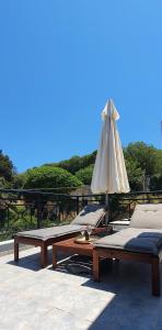 2 bedden en een parasol op een patio bij Rodos Beach Apartment 33 in Rhodos-stad