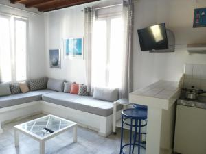 a living room with a couch and a table at Petit Andromeda Mykonos I in Mikonos