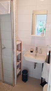 a white bathroom with a sink and a mirror at Apartment Charly - Aktivurlaub im Herzen Bayerns in Wolfersdorf +19 photos