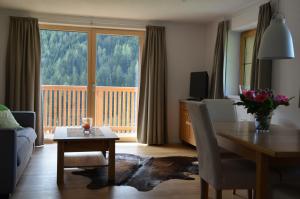 a living room with a dining room table with a view at Haus Nick, Appartementhaus in Sankt Anton am Arlberg