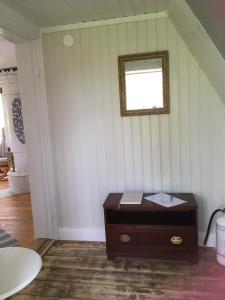 um quarto com uma mesa e um espelho na parede em Fråsttorp em Aneby