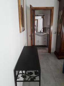 La salle de bains est pourvue d'une table noire et d'un lavabo. dans l'établissement B&B Let&Lat, à Marcheno
