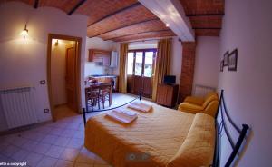 a bedroom with a bed and a living room at Oasi Del Grillo in Castelnuovo Berardenga