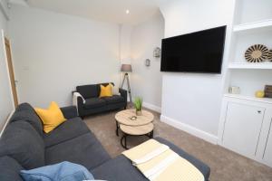 uma sala de estar com um sofá e uma televisão de ecrã plano em The Hideaway - IH113AHIG em Stockton-on-Tees