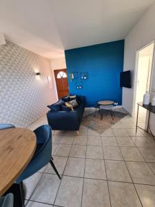 Les Terrasses de Sari في ساري سولينزارا: غرفة معيشة مع أريكة والجدار الأزرق