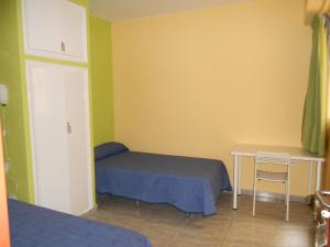 a bedroom with a bed and a desk and a table at Pensión Mova in Santa Cruz de Tenerife