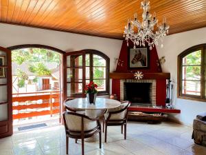een woonkamer met een tafel en een open haard bij Pousada da Lua in Campos do Jordão