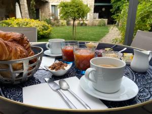 a table with a cup of coffee and croissants on it at La Planque - Chambres avec Jacuzzi in Fleury-en-Bière