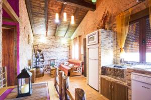 a kitchen and living room with a brick wall at LOS SUEÑOS DE JAVIER in Robledillo