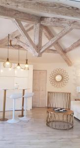 un soggiorno con soffitti in legno, tavolo e sedie. di Studio villa château Currault a Mougins