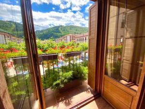 a view from a window of a balcony with flowers at Apartamentos Turísticos Ezcaray in Ezcaray