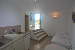 a bathroom with a toilet and stairs in the background at ThalaSEA - village Antiparos in Antiparos