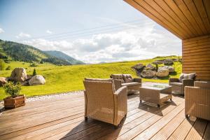 a deck with chairs and a table and a view of a hill at Apartmány Tatry Žiarce in Liptovský Mikuláš
