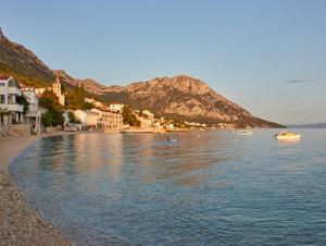 a beach with houses and boats in the water at Apartmani-Asja in Brist +9 photos