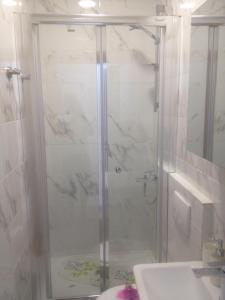 a shower with a glass door in a bathroom at Apartmani-Asja in Brist