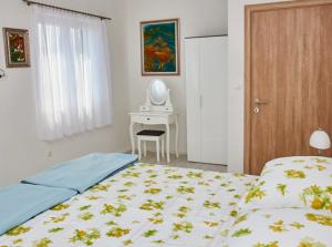 a bedroom with a bed and a desk with a mirror at Apartmani-Asja in Brist