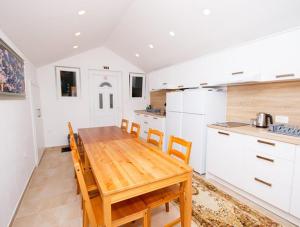 a kitchen with a wooden table and chairs at Apartmani-Asja in Brist