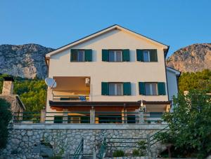 a large house on top of a stone wall at Apartmani-Asja in Brist