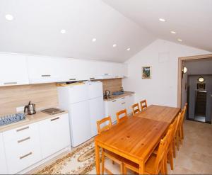 a kitchen with a wooden table and chairs in it at Apartmani-Asja in Brist