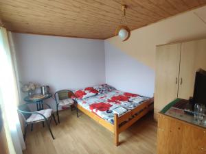 a small bedroom with a bed and a table at Przy Winogronie in Uherce Mineralne (7)