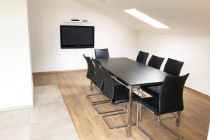 une salle de conférence avec une table et des chaises noires dans l'établissement 4 Zimmer Ferienwohnung Egelsbach, à Egelsbach