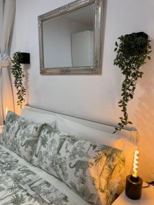 um espelho numa parede por cima de um sofá com uma almofada em Dream Recova em Santa Cruz de Tenerife