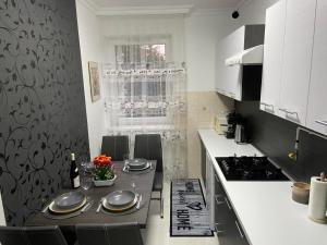 uma cozinha com uma mesa com cadeiras e um fogão em Melinda Apartman em Kisvárda