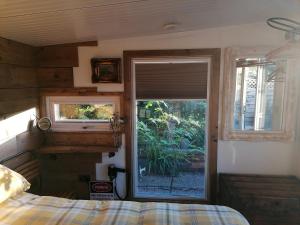 een slaapkamer met een raam en een bed in een kamer bij Crown Cabin Wiltshire near Longleat and Bath in Trowbridge