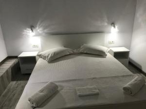 a white bed with pillows and two lights on top at CasaRiana 4 in Eforie Sud