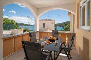 une table et des chaises sur un balcon avec vue sur l'eau dans l'établissement Villa A Marina, à Marina