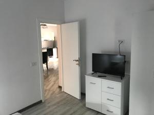 a living room with a television on a white dresser at R i A N A 4 in Eforie Sud