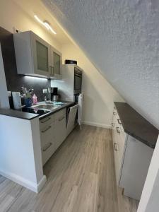 a kitchen with white cabinets and a sink at Studio-Apartment Ankerplatz im Ferien-Resort Rügen in Neddesitz