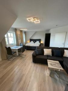 a living room with a couch and a bed at Studio-Apartment Ankerplatz im Ferien-Resort Rügen in Neddesitz