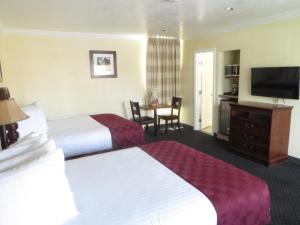 a hotel room with two beds and a flat screen tv at Best Inn & Suites in Anaheim +24 photos