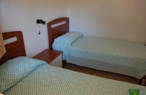 a bedroom with two beds and a nightstand and two beds sidx sidx at MIMOSA CAMPING in Isca sullo Ionio