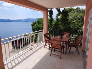 a balcony with a table and chairs and a view of the water at Bella Vista in Komarna