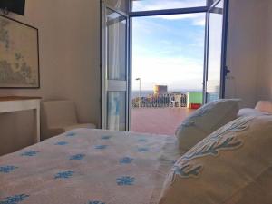 a bed sitting in front of a window in a hotel room at Hotel Da Cecco in Santa Teresa Gallura
