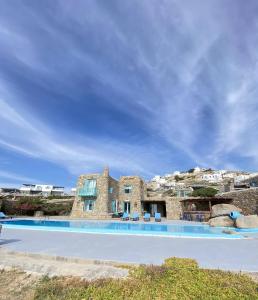 ein großer Pool vor einem Steinhaus in der Unterkunft Villa Casa De Blue in Mykonos Stadt