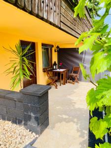 a patio with a table and a yellow house at Ferienwohnung in Stockach am Bodensee in Stockach