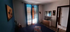 a room with a bed and a window and a mirror at Casa Sabrina in San Vito lo Capo