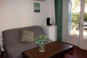 un soggiorno con divano e tavolo con vaso di VILLA BLEUE - LES PINS a Port-Vendres