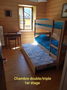 a bedroom with two bunk beds in a cabin at Gîte de la snaille in Le Reposoir