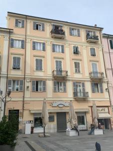 サンレモにあるA Due Passi - Sanremo Apartmentsの傘が前に置かれた大きな建物